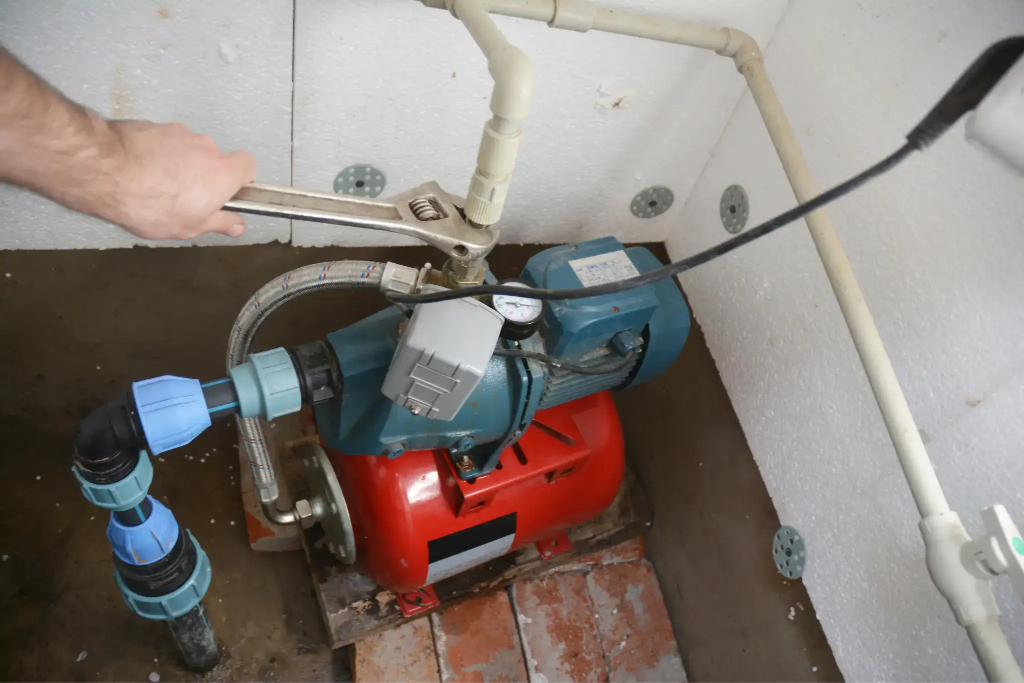 Wrench adjusting a connection on a domestic water pump
