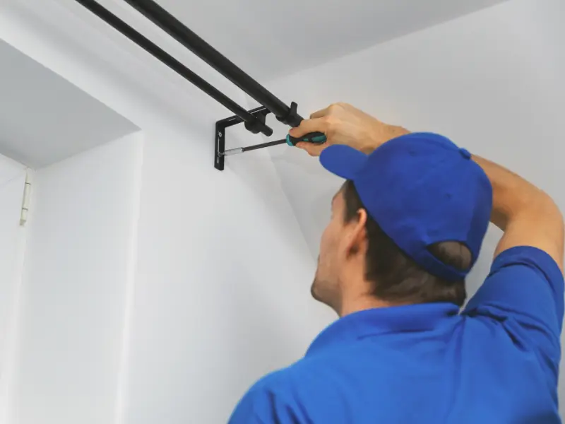 Illustrative installer securing a curtain-rod bracket